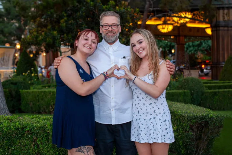 Family photo of father with his daughters in front of the Bellagio Hotel in Las Vegas.