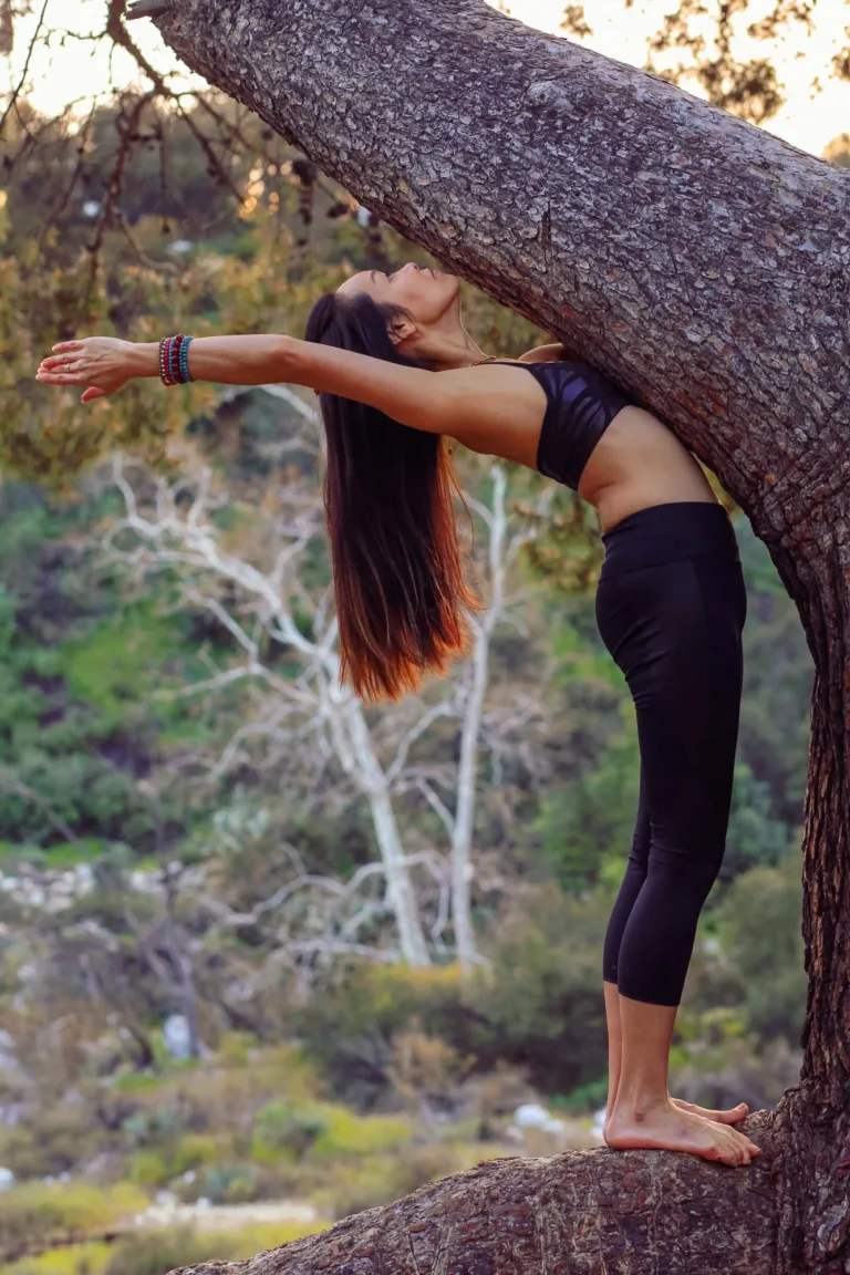 Portrait of a woman performing a yoga pose in a tree on a nature trail in Altadena, California.