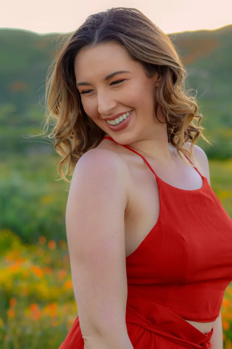 She is all smiles posing for a beautiful sunset portrait at the blooming poppy fields in Lake Elsinore, California.