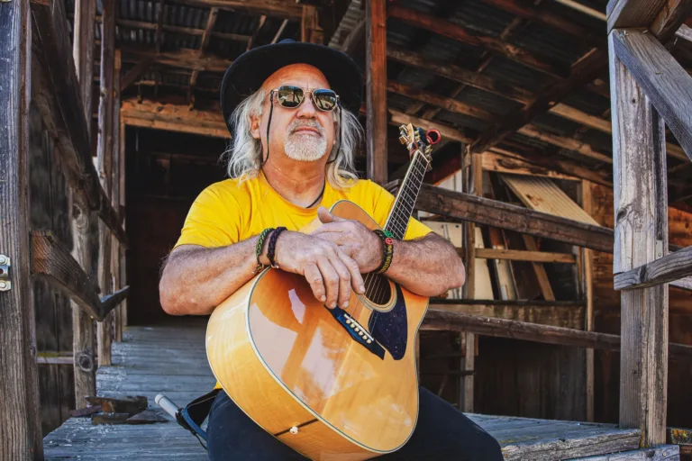 Older gentleman holding his guitar candidly for a personal portrait in Northern California.